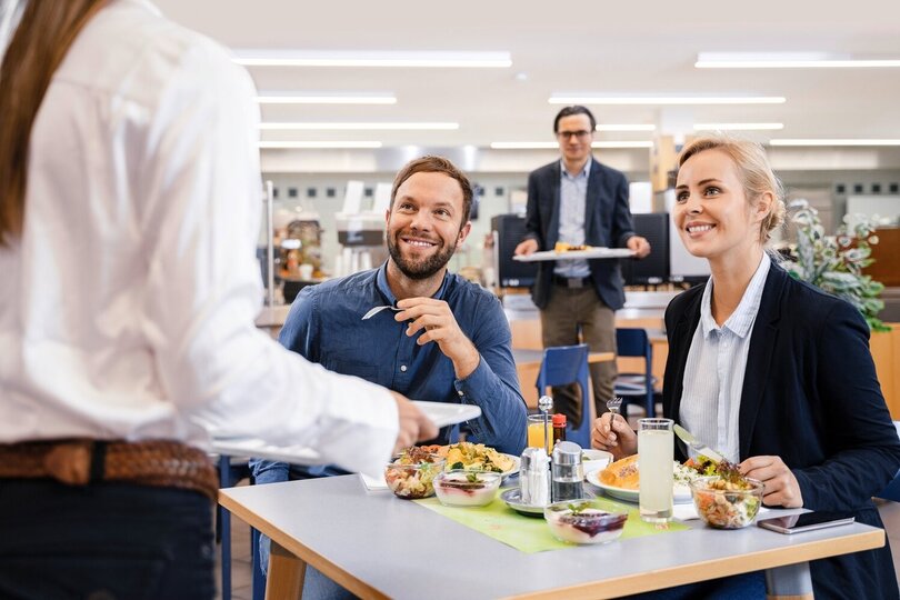 Man and women eat lunch in canteen